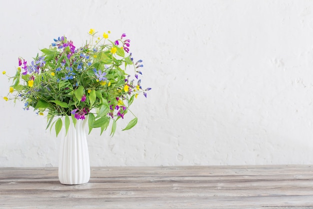 Summer wild flowers in vase on white background