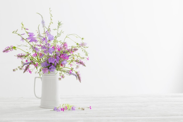 白い背景に白い水差しの夏の野生の花