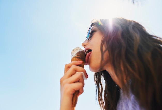 Photo summer below and a woman with ice cream on a blue sky for freedom travel and sweet food sun holiday and a young girl with a dessert during a vacation in spring or a eating gelato and thinking