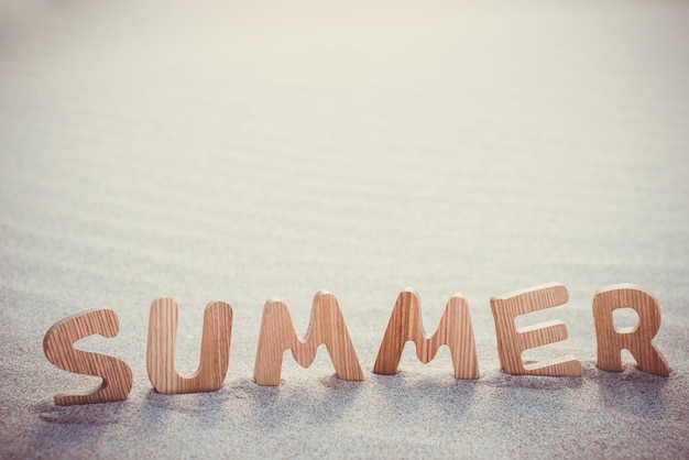 Photo summer wooden letters on the sand