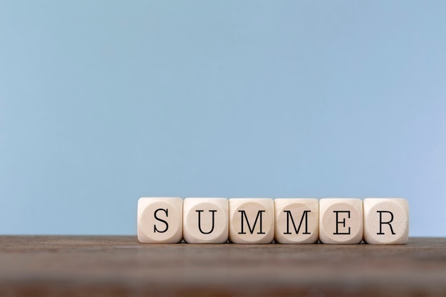 Summer word written in wooden cube on wooden table