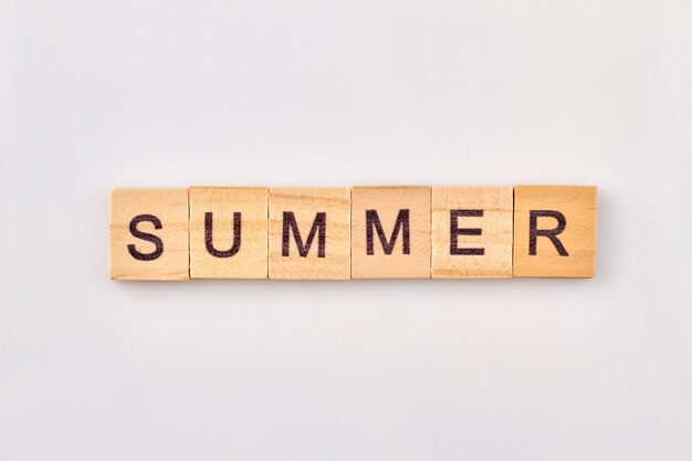 Summer word written in wooden cubes. Concept of season isolated on white background.