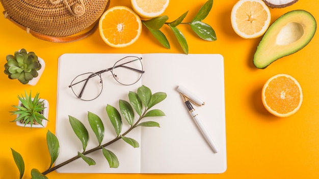 Summer workplace layout with notepad and fruit