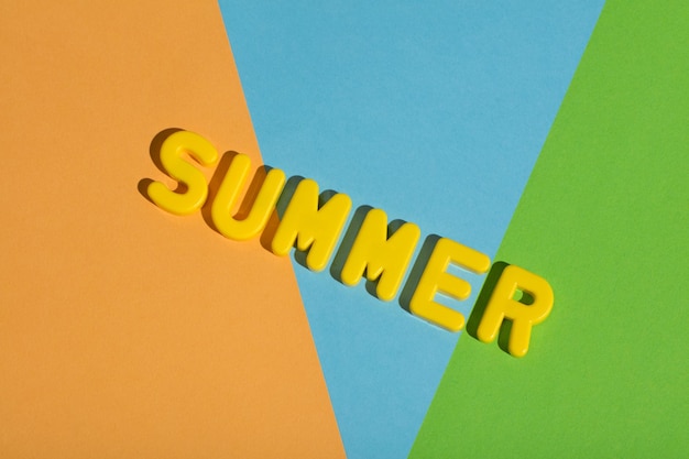 Photo summer writing on a colorful pastel background made from yellow letters vacations