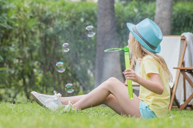 Summertime fun. Cute child girl blowing soap bubbles and having fun