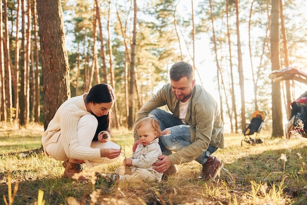 Summertime happiness Family of father mother and little daughter is in the forest