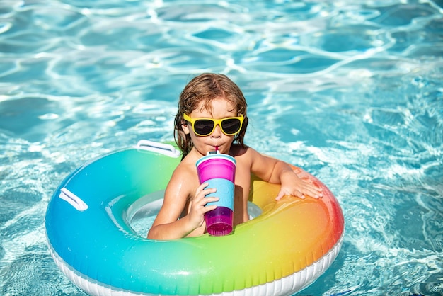 Summertime vacation funny child boy relax at aquapark drink cocktail