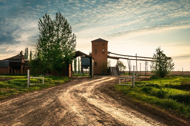 写真 太陽と雲が道路の上のフィールドを覆う 素晴らしい風景