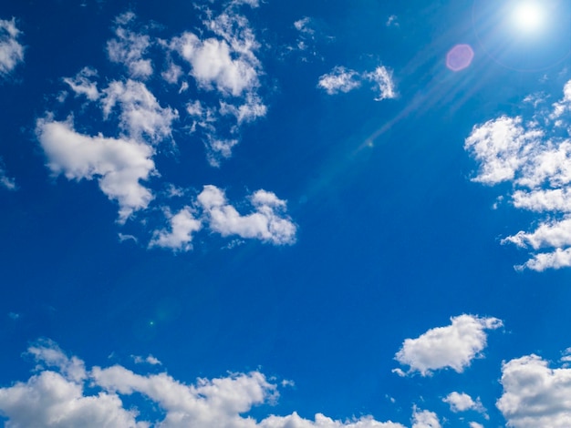 Sun on a background of blue sky with clouds