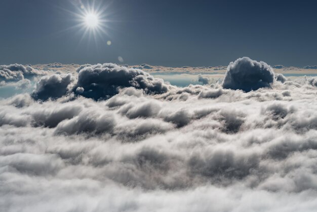 嵐の雲の上の青い空に太陽