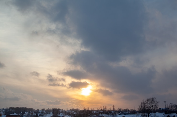 Photo the sun among the clouds over the winter city.