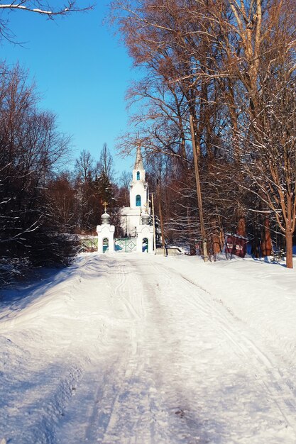 Солнечная дневная церковь в зимнем лесу