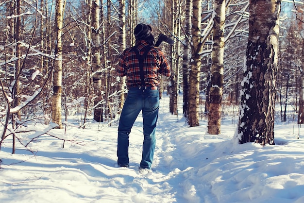 Sun day man with axe in the forest