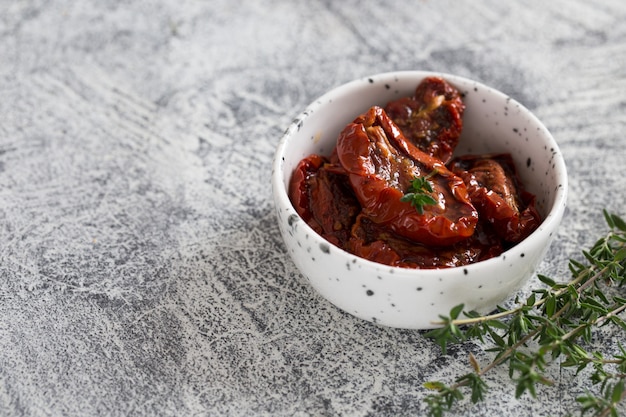 가벼운 콘크리트 배경에 접시에 햇볕에 말린 토마토