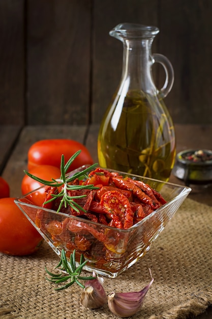 Sun-dried tomatoes with herbs and garlic in wooden bowl