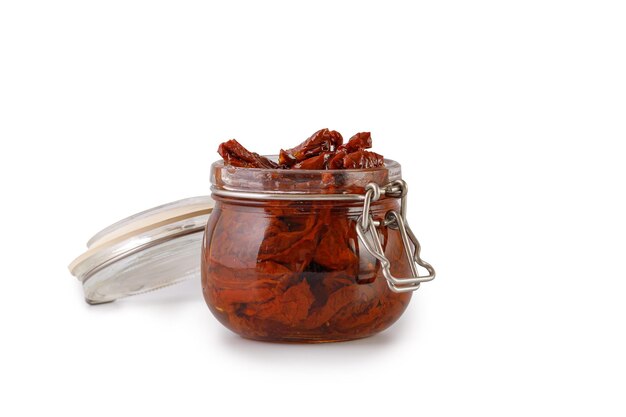 Sun dried tomatoes with olive oil in glass jar isolated on a white background clipping path cut out