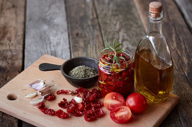 Sun-dried tomatoes with Provencal herbs, garlic and olive oil on a rustic wooden surface