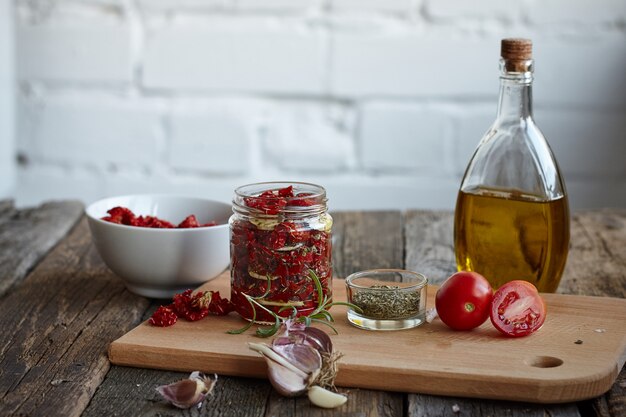 Sun-dried tomatoes with Provencal herbs, garlic and olive oil on a rustic wooden surface