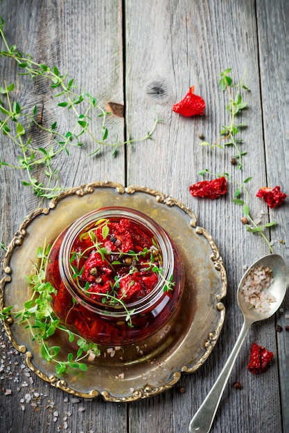 Sun-dried tomatoes with thyme in a glass jar