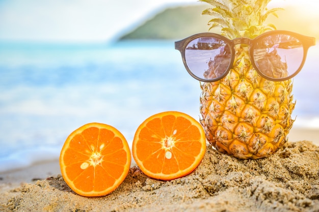 Sun glass is on pineapple at beach sea view background,Summer holiday concept