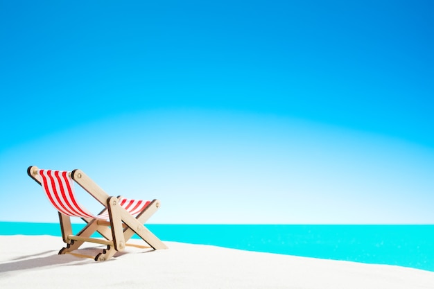 Sun lounger on the sandy beach by the sea and sky with copy space