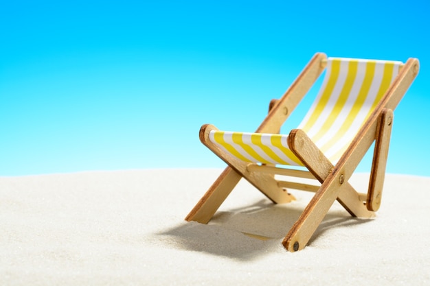 Sun lounger on the sandy beach and sky with copy space