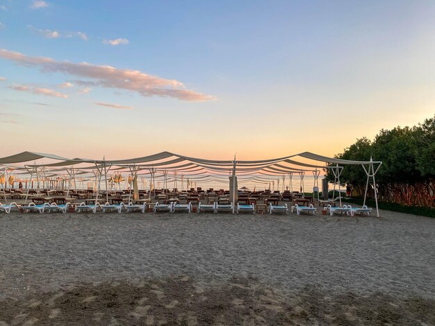 Sun loungers and sunshade with umbrellas on the beach on the sea on vacation in a tourist warm eastern tropical country southern resort