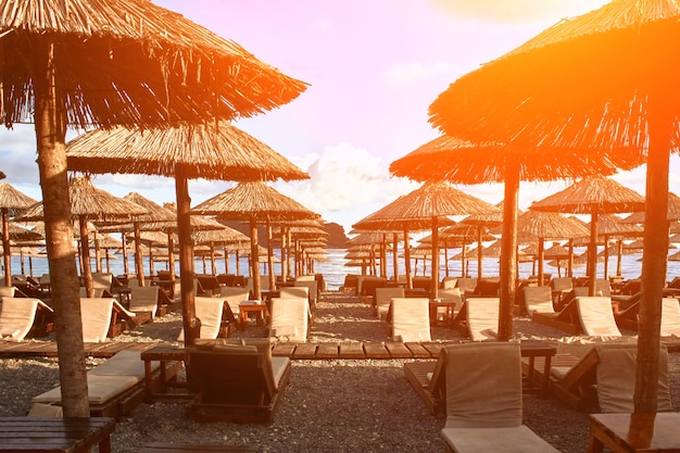 부드바 몬테네그로 태양 플레어의 해변에 일광욕용 라운저와 우산이 있습니다.