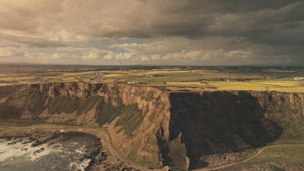 Sun ocean bay coast aerial nobody nature landscape cliff grass valley farms at countryside rural