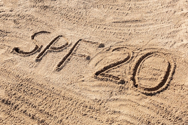 Солнцезащитный фактор двадцать концепция SPF 20 слово написано на пляже