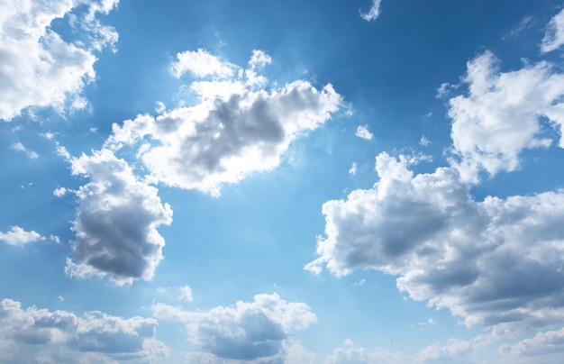 青い空の雲の後ろの太陽光線曇りの天気