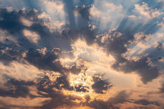 Солнечные лучи пересекают облака и проходят через них с Солнцем в центре, покрытым облаками.