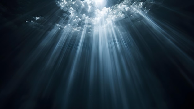 Sun rays and light shining through surface of ocean seen from underwater on black background