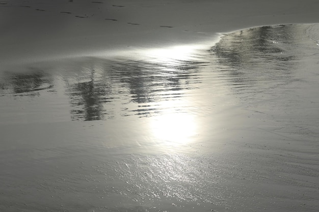 写真 濡れた砂の太陽の反射