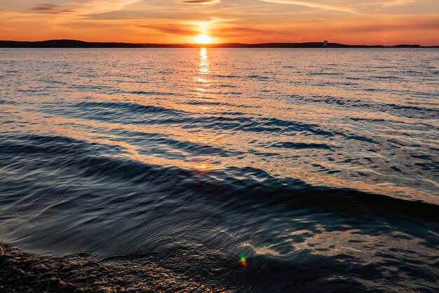 Солнечные лучи отражаются в воде на закате