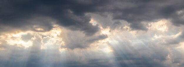 日没、パノラマの間に太陽の光線が暗い雲を透過します