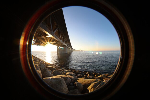 Photo sun seen through the oresund bridge at the viewpoint near limhamn sweden wide angle clear sky