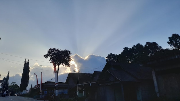 the sun sets behind a house