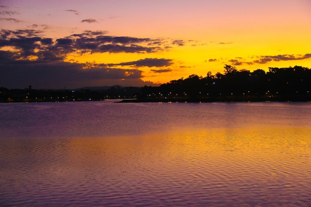 Photo sun setting with silhouette pond.