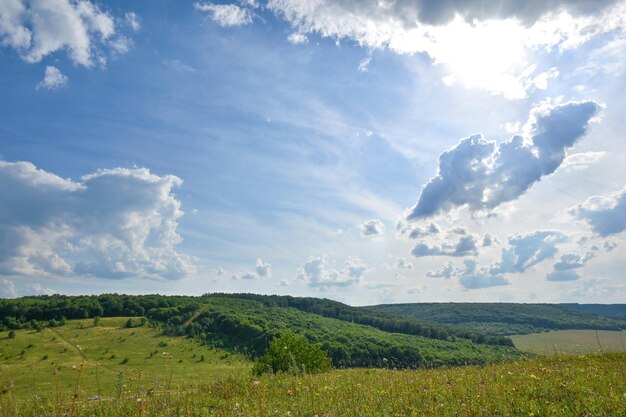 the sun shines through beautiful clouds on a picturesque plain