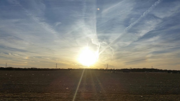 写真 耕作された畑の上に輝く太陽