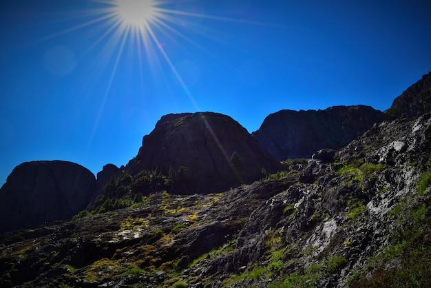 Sun shining through clouds over mountain