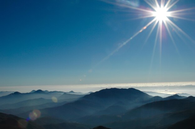 Foto il sole splende attraverso le nuvole sopra le montagne