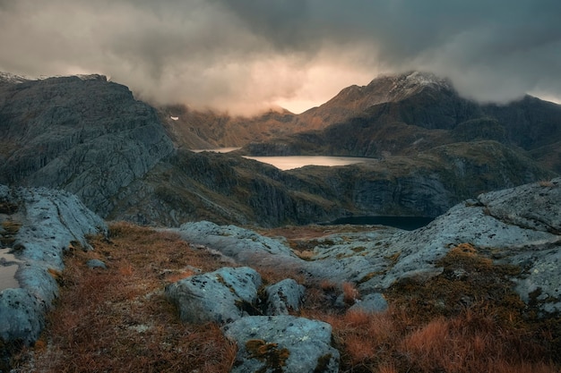 Sun shining through rain clouds over a lake in the Norwegian mountains on the Lofoten Islands