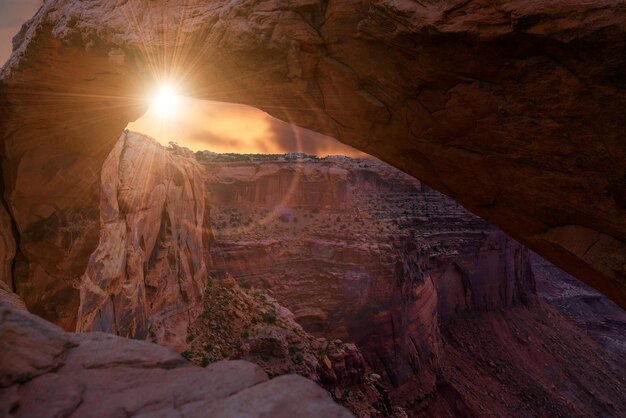 Photo sun shining through rocks