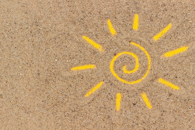 Sun sign drawn on sand. Creative top view Copy space
