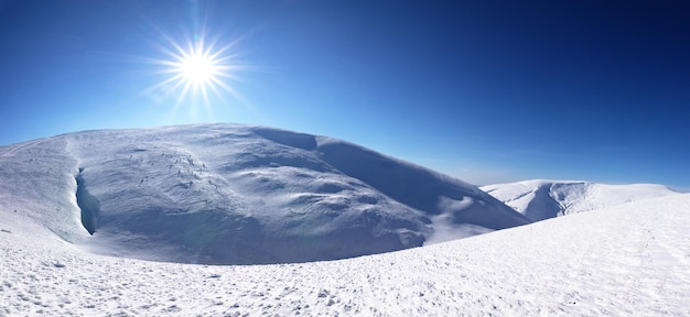 雪に覆われた冬の山々 の太陽