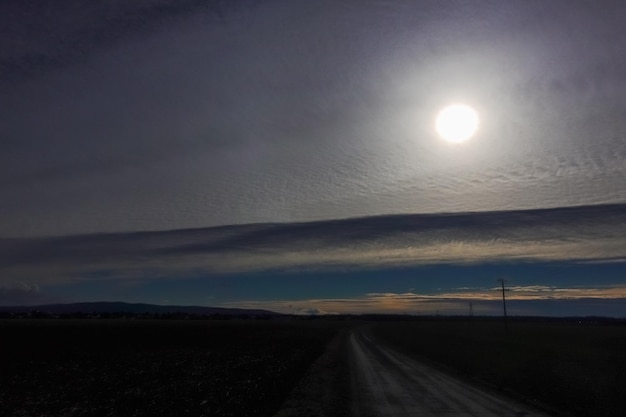 Foto sole dietro meravigliose nuvole bianche in un paesaggio