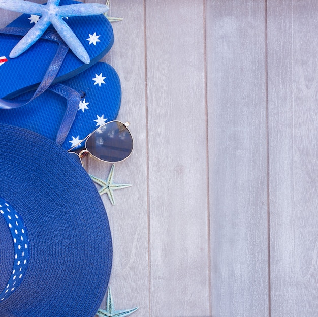 Sunbathing accessories and straw hat with copy space on wooden background