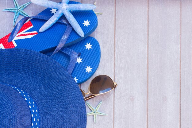 Sunbathing accessories and straw hat on wooden background